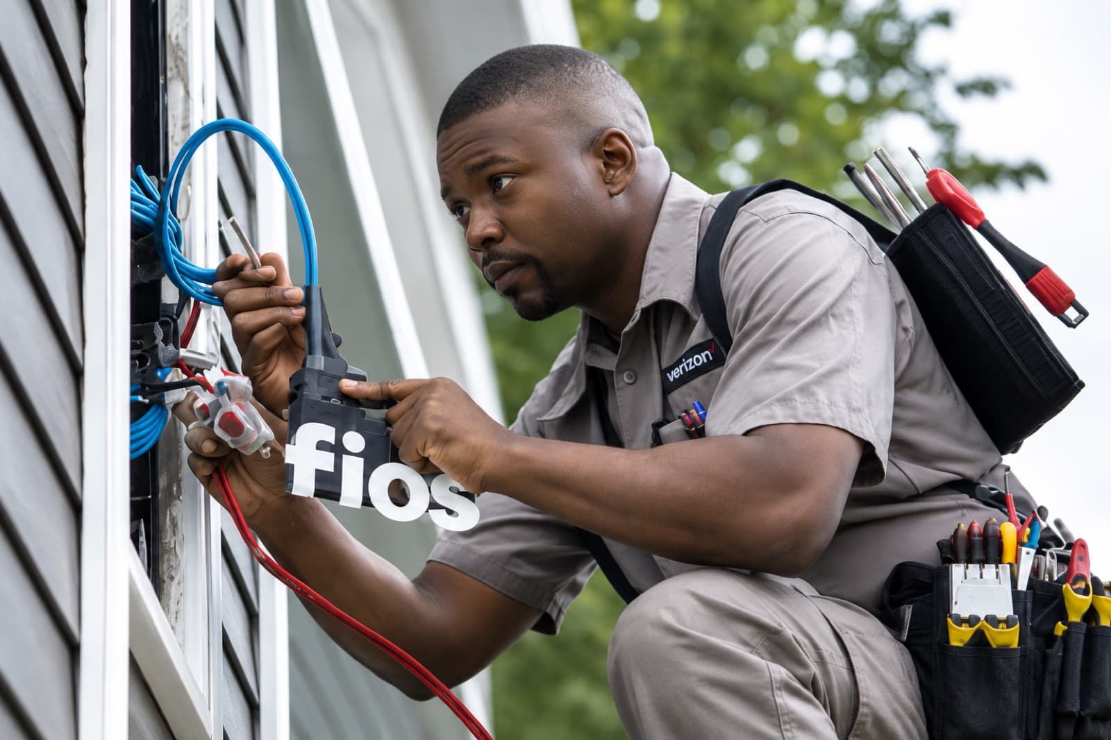 Illustrative close-up of an internet technician working on exterior fiber cabling